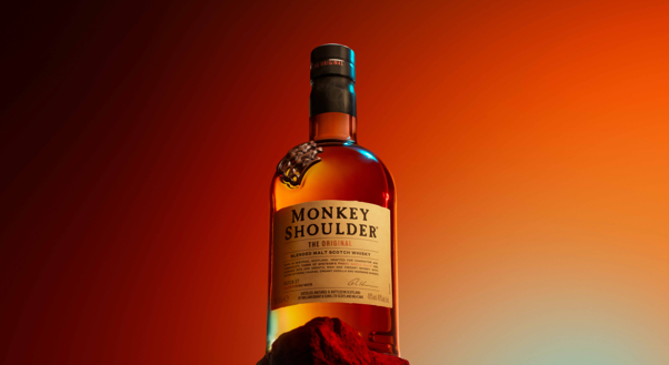Monkey Shoulder whisky bottle with red background