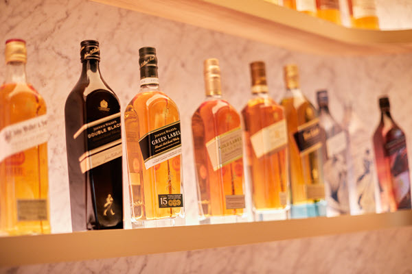 (A range of Johnnie Walker bottles on a bar shelf, in front of a marble wall) Diageo's sales were excellent last year, but now they need to get creative to shift bottles off shelves