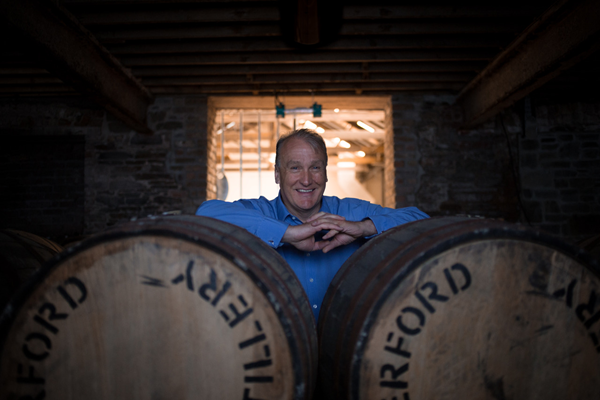 Mark Reynier behind two barrels at Waterford Distillery