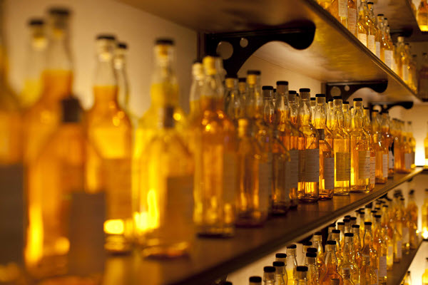 (Hundreds of sample bottles of whisky on mahogany shelves)